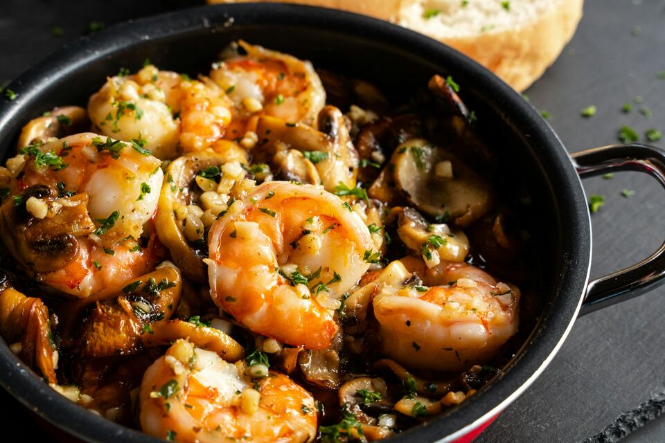 Frigideira de ferro com gambas ao alho e salsa